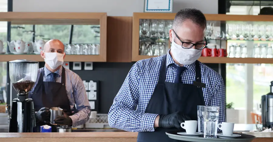 Coronavirus: waiters in a café with medical protective equipment